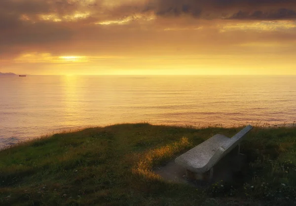 Bank bei Sonnenuntergang am Meer — Stockfoto