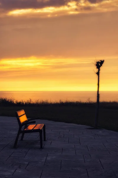 Bench at sunset near the sea — Stock Photo, Image