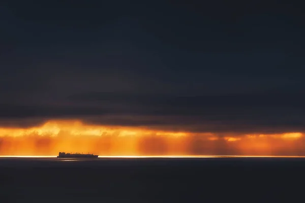 Sunrays on the ocean with freighter ship — Stock Photo, Image