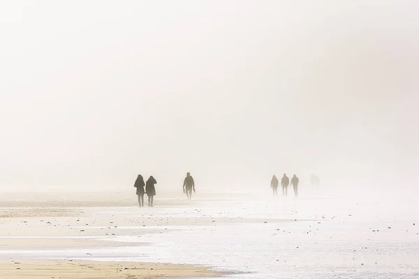 Люди ходять з піщаною бурею на пляжі — стокове фото