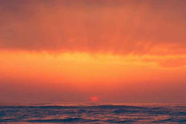 Красный закат с солнечными лучами — стоковое фото