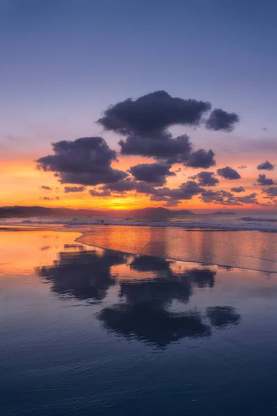 Bulutlar yansımaları sahilde — Stok fotoğraf