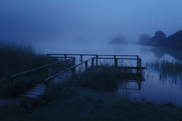 Mystiska träbryggan vid sjön på natten — Stockfoto