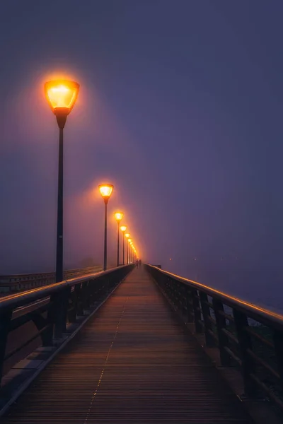 Coppia che cammina su strada buia illuminata con lampioni — Foto Stock
