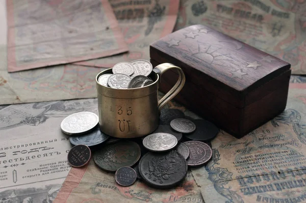 Altes russisches Papiergeld und Silbermünzen mit Becher und Holzkiste — Stockfoto