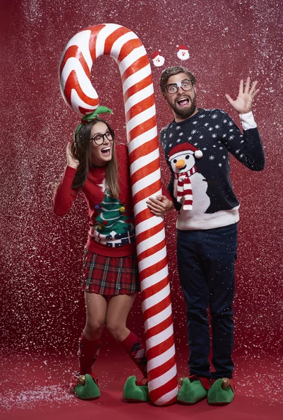 Couple debout avec canne de Noël rouge et blanche — Photo