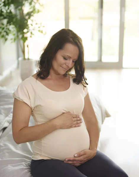Mulher grávida acariciando seu abdômen — Fotografia de Stock