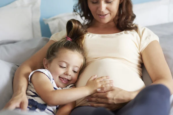 Беременная женщина и ее маленькая дочь — стоковое фото