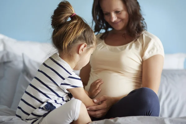 Zwangere vrouw en haar dochtertje — Stockfoto