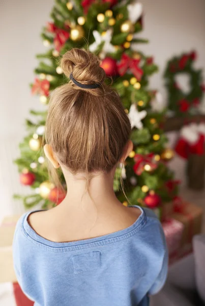 Kleines Mädchen schaut auf Weihnachtsbaum — Stockfoto