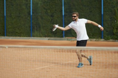 Güneşli günde tenis oynamaya adam
