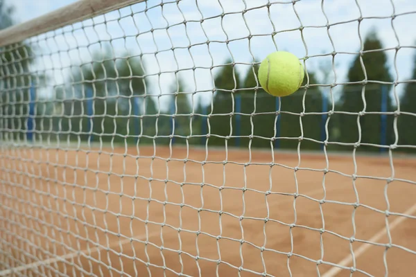 Теннисный мяч бьет по сетке — стоковое фото