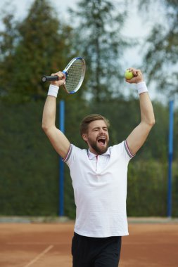 Genç adam tenis oynuyor.
