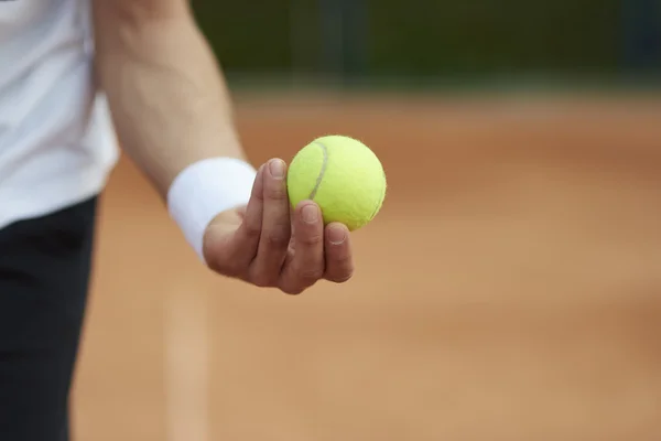 Игрок держит теннисный мяч — стоковое фото