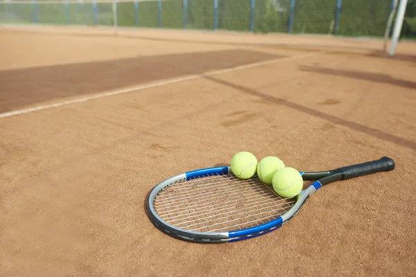 Теннисные мячи и теннисная ракетка — стоковое фото
