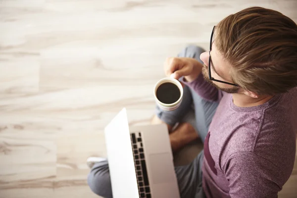 Man sitting on the wooden floor — Stock Photo, Image