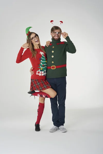 Люди в красочных рождественских прыгунах в смешной праздничной концепции — стоковое фото