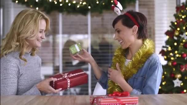 Women giving Christmas gifts to each other — Stock video