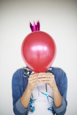 Kadın kırmızı bir balon saklanıyor