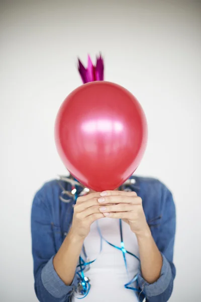 Woman hiding behind a red balloon — Stock fotografie