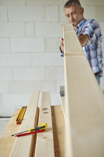 Tischler versucht Holzplanke zu vermessen — Stockfoto