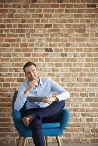 Homme d'affaires posant sur un fauteuil bleu — Photo