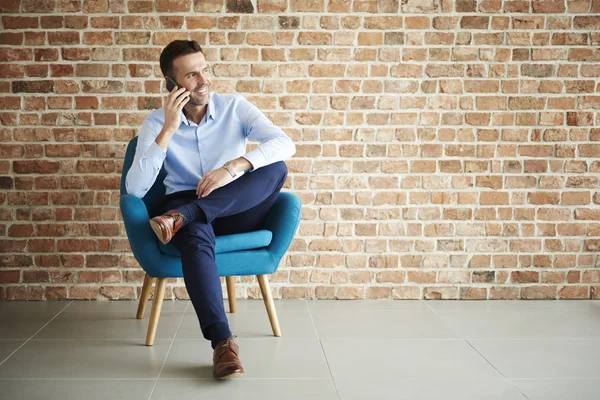 Empresario posando en sillón azul —  Fotos de Stock