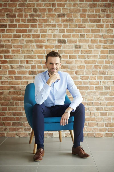 Empresario posando en sillón azul — Foto de Stock