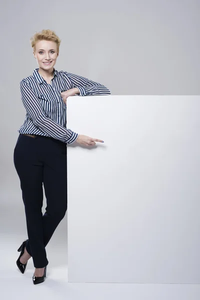 Woman leaning on a white placard — Stock Photo, Image
