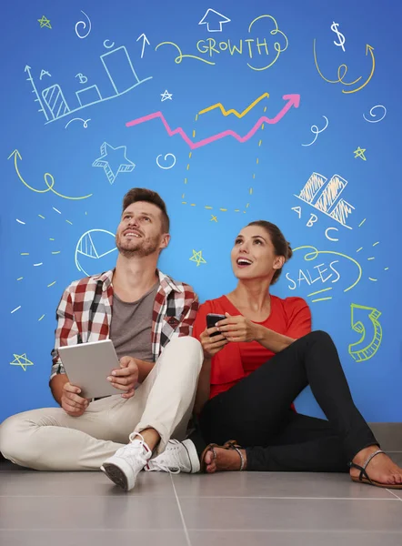 Adam ve kadın dijital cihazlar ile oturuyordu