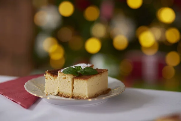 Cheesecake és karácsony fa a háttérben — Stock Fotó