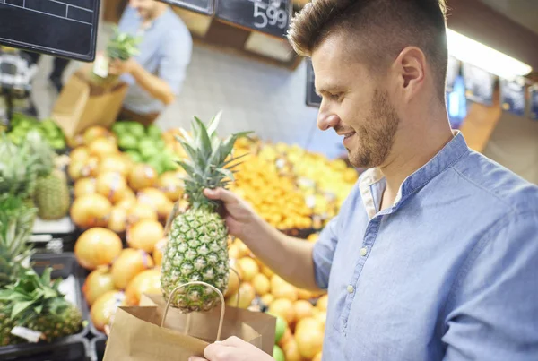 Ung man köper färsk och hälsosam frukt — Stockfoto