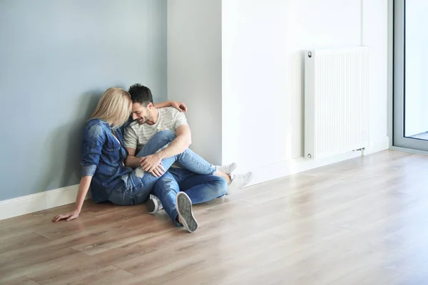 Casal sentado no chão e abraçando — Fotografia de Stock