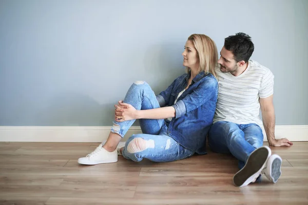 Couple sitting on floor and hugging — Stock Photo, Image