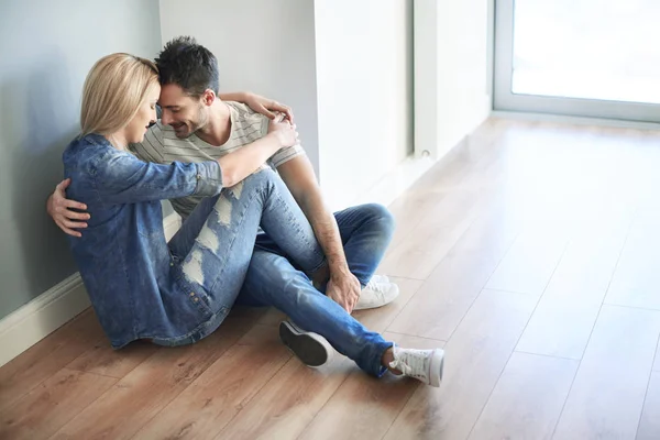 Par sitter på golvet och kramas — Stockfoto