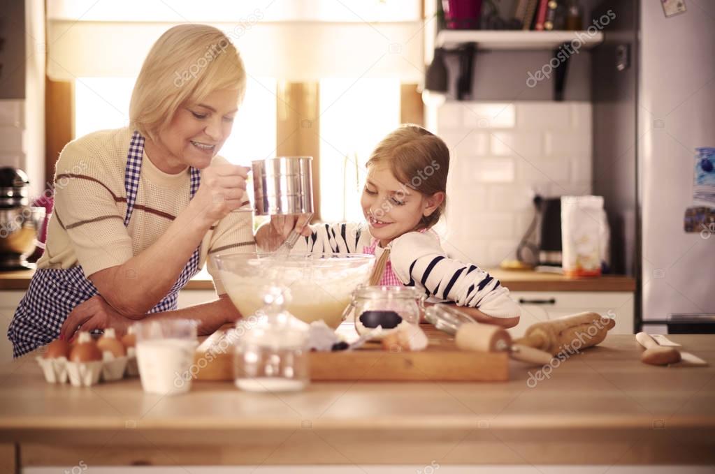 Girl with grandmother making dough