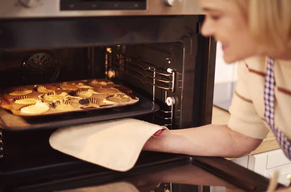 Mulher puxando muffins — Fotografia de Stock