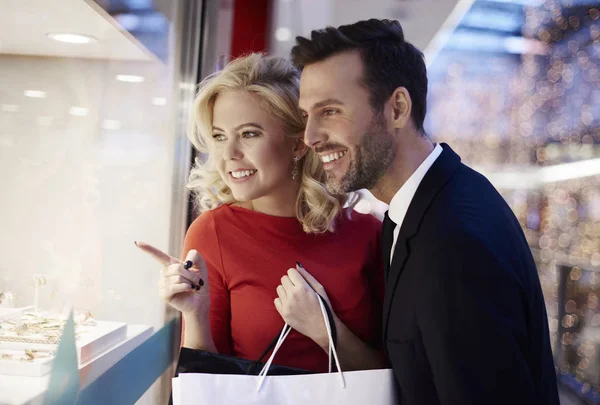 Couple watching through storefront — Stock Photo, Image