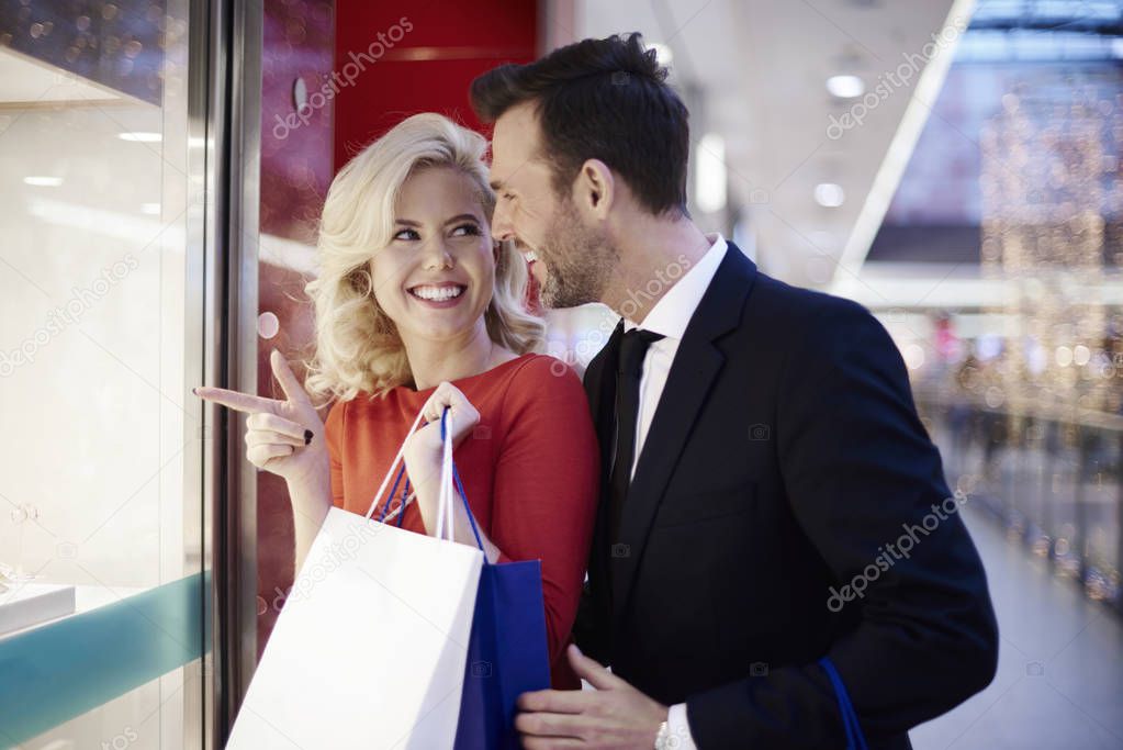 couple watching through storefront