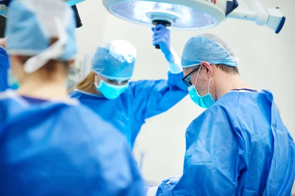 Médicos ocupados sobre a mesa de operação — Fotografia de Stock