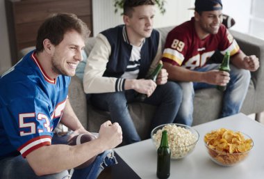 Spor oyunu izlerken arkadaşlar