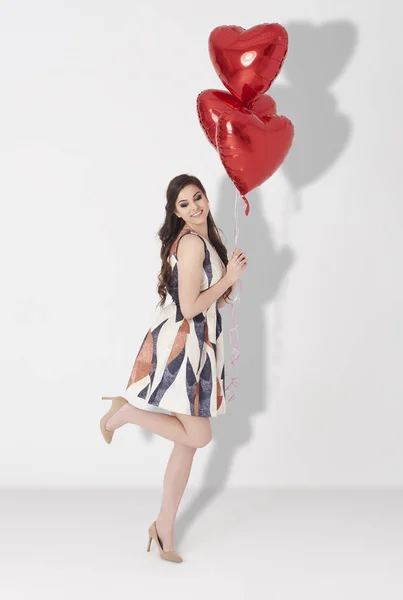 Kvinna innehav ballonger — Stockfoto