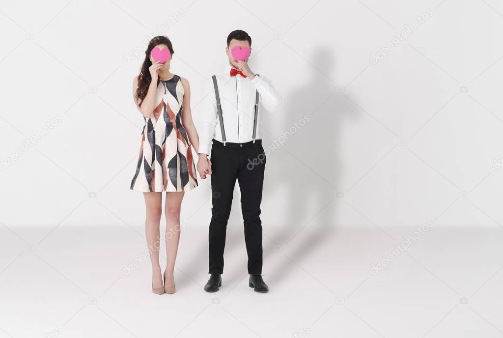 Couple holding paper hearts