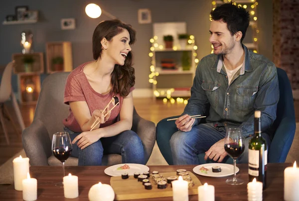 Pareja tratando de comida japonesa — Foto de Stock