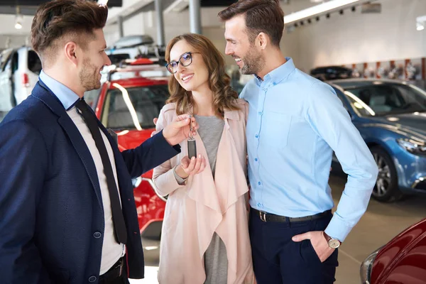 Paar en auto verkoper in de winkel — Stockfoto