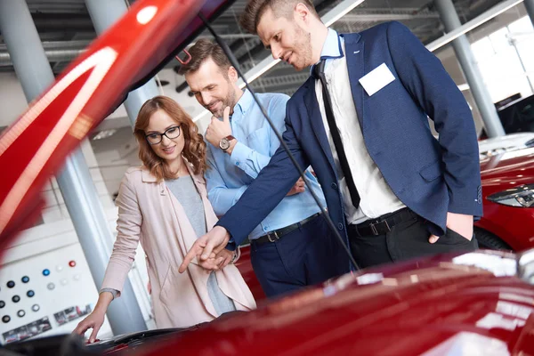 Couple and car salesman in shop — Stock Photo, Image