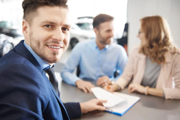 Ehepaar und Autoverkäufer im Geschäft — Stockfoto