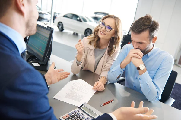 Pareja y vendedor de coches en la tienda — Foto de Stock