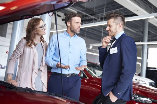 Pareja y vendedor de coches en la tienda — Foto de Stock