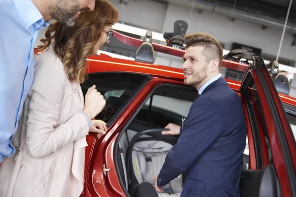 Couple et vendeur de voitures dans le magasin — Photo